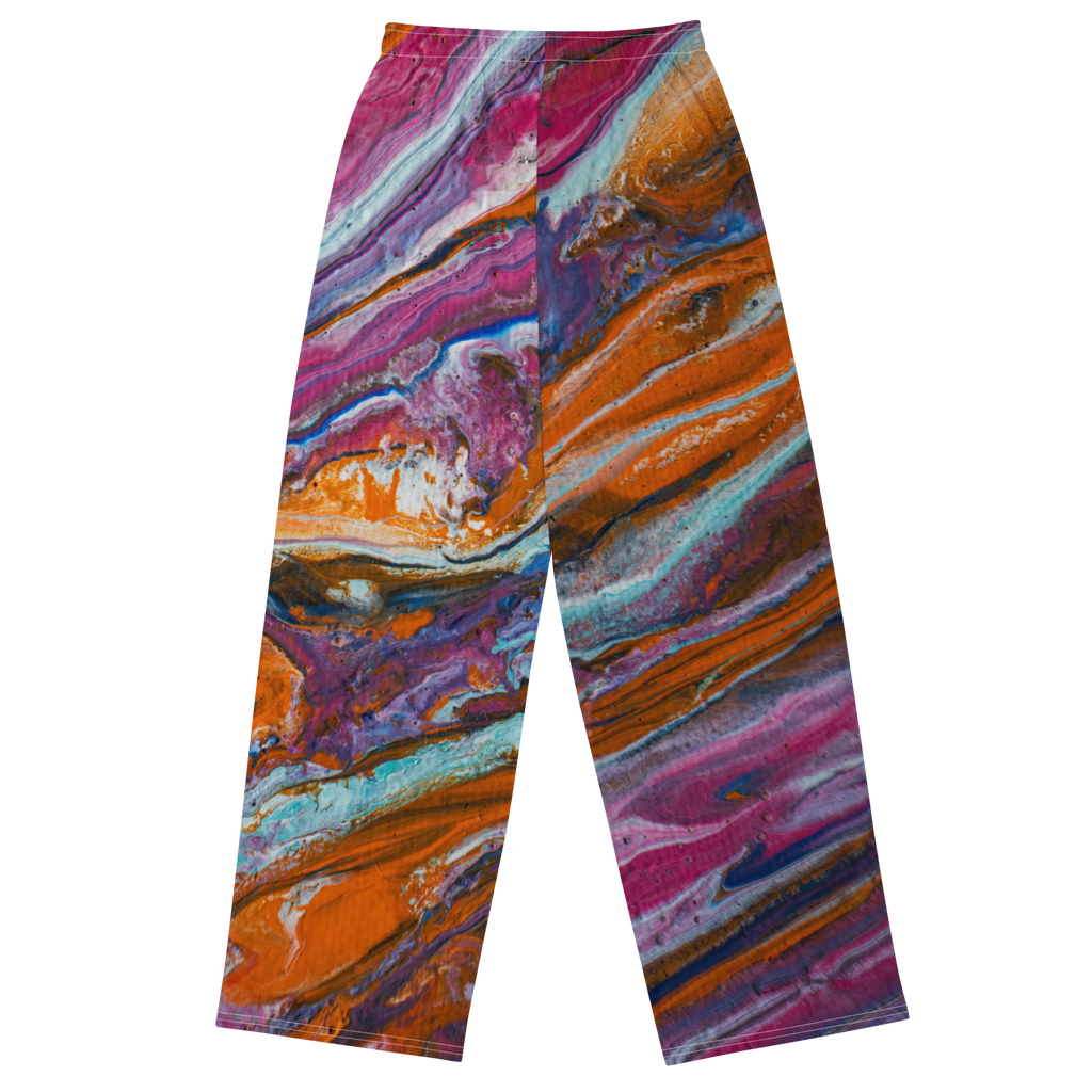 Unisex wide-leg pants featuring a vibrant paint pour design by Yurmaze in pink, orange, and blue tones, worn as comfortable lounge trousers.